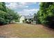 Beautiful home backyard featuring a spacious lawn, mature trees, and a screened-in porch for outdoor enjoyment at 151 Overhill Point, Alpharetta, GA 30005