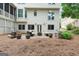 Backyard view with a stone patio, fire pit, and seating surrounded by lush landscaping at 151 Overhill Point, Alpharetta, GA 30005
