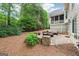 Spacious stone patio featuring comfortable outdoor seating and a fire pit, surrounded by lush greenery at 151 Overhill Point, Alpharetta, GA 30005