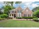 Charming two-story brick home with a manicured lawn and landscaping at 151 Overhill Point, Alpharetta, GA 30005