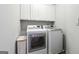 Modern laundry room features white cabinets, washer, dryer, and ample space for cleaning at 151 Overhill Point, Alpharetta, GA 30005