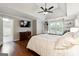 Bright main bedroom with hardwood floors, a ceiling fan, TV, and ensuite bathroom with modern finishes at 151 Overhill Point, Alpharetta, GA 30005