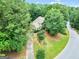 Aerial view of the home with a long driveway, lush landscaping, mature trees, and an attached garage at 164 Interlochen Dr, Peachtree City, GA 30269