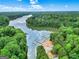 Scenic aerial shot of a lake with docks, surrounded by lush green trees and a partially cloudy sky at 164 Interlochen Dr, Peachtree City, GA 30269
