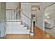Bright foyer with hardwood floors, a staircase with white banisters, and views into other rooms at 164 Interlochen Dr, Peachtree City, GA 30269