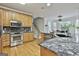 Spacious kitchen features stainless steel appliances, granite countertops, hardwood floors and eat-in dining area at 164 Interlochen Dr, Peachtree City, GA 30269