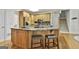 Kitchen island with marble countertops, wooden cabinets, and breakfast bar seating at 164 Interlochen Dr, Peachtree City, GA 30269