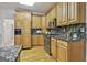 This kitchen has stainless steel appliances, beautiful granite counters, wood cabinets, and hardwood floors at 164 Interlochen Dr, Peachtree City, GA 30269