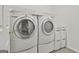 Functional laundry room with a washer, dryer, and storage shelves at 164 Interlochen Dr, Peachtree City, GA 30269