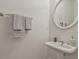 Modern powder room with a pedestal sink, oval mirror, and towel rack at 164 Interlochen Dr, Peachtree City, GA 30269
