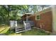 View of the back deck of this home with stairs to the wooded back yard, plus the side of the red-brick home at 766 Virginia Cir, Forest Park, GA 30297