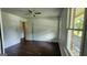 A well-lit bedroom featuring a ceiling fan, wood floors, and a view of the outside at 766 Virginia Cir, Forest Park, GA 30297
