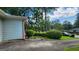 Driveway shot showing the side of the home with blue siding and a view of the landscaped front yard at 766 Virginia Cir, Forest Park, GA 30297