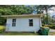 Exterior shot of the home showing two windows, plus garbage cans and bags alongside the blue-painted siding at 766 Virginia Cir, Forest Park, GA 30297