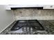 Close-up of the cooktop featuring granite countertops and tile backsplash at 766 Virginia Cir, Forest Park, GA 30297