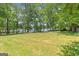 Expansive backyard with a level lawn and mature trees, offering privacy and ample space at 23 Skyland W Dr, Locust Grove, GA 30248
