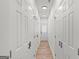 Hallway featuring several closet doors and wood-look floors at 23 Skyland W Dr, Locust Grove, GA 30248