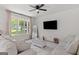 Comfortable living room with a cozy sofa, TV, and large window with natural light at 23 Skyland W Dr, Locust Grove, GA 30248