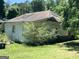 Exterior side view of an abandoned house with siding and a door at 72 N Pomona N Rd, Hampton, GA 30228
