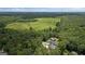 Aerial view of a home nestled among lush greenery and an expansive field, showcasing its serene setting at 2490 S Carroll St, Villa Rica, GA 30180