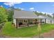 Spacious backyard featuring an outdoor patio, lush green lawn, and surrounding trees at 2490 S Carroll St, Villa Rica, GA 30180