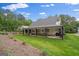Expansive backyard featuring a covered patio, lush green lawn, and mature trees at 2490 S Carroll St, Villa Rica, GA 30180
