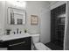 Well-lit bathroom with a modern vanity, framed mirror, toilet, and shower with decorative tile and rainfall showerhead at 2490 S Carroll St, Villa Rica, GA 30180