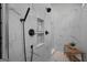 Walk-in shower featuring white marble walls, pebble flooring, decorative shelves, and matte-black hardware at 2490 S Carroll St, Villa Rica, GA 30180