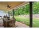 Covered patio with dining table and chairs overlooking a grassy lawn and wooded area at 2490 S Carroll St, Villa Rica, GA 30180