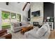 Inviting living room featuring a floor-to-ceiling stone fireplace, vaulted ceilings with wood beams, and lots of natural light at 2490 S Carroll St, Villa Rica, GA 30180