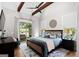 Spacious main bedroom featuring wood-beamed ceilings, a ceiling fan, and access to an outdoor patio at 2490 S Carroll St, Villa Rica, GA 30180