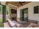 Cozy covered outdoor patio with a brick fireplace, mounted TV, comfortable seating, and ceiling fan at 2490 S Carroll St, Villa Rica, GA 30180