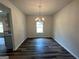Well-lit dining room features hardwood floors, neutral walls, and a modern chandelier; a window and doorway add dimension at 142 Tye St, Stockbridge, GA 30281