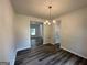 Well-lit dining room features hardwood floors, neutral walls, and a modern chandelier; a window and doorway add dimension at 142 Tye St, Stockbridge, GA 30281