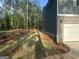 Side view of home's exterior with dark siding, brick foundation, and a white garage door at 142 Tye St, Stockbridge, GA 30281
