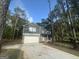 Two-story home featuring a gray facade, a brick-accented front, and an attached two-car garage with a long concrete driveway at 142 Tye St, Stockbridge, GA 30281