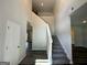 Bright foyer featuring hardwood floors and a staircase leading to the second level, with an open doorway and neutral walls at 142 Tye St, Stockbridge, GA 30281