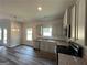 Well-lit kitchen with hardwood floors, gray cabinets, granite countertops, stainless appliances and access to the backyard at 142 Tye St, Stockbridge, GA 30281