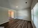 Bright living room featuring hardwood floors, neutral walls, and a window offering natural light; a doorway leads to another room at 142 Tye St, Stockbridge, GA 30281