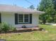 The side view of the home has a well maintained lawn and white painted brick exterior with black shutters at 4814 Glenwood Rd, Decatur, GA 30035