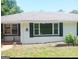 Charming single-story home featuring a gray roof and a freshly painted white brick exterior with black shutters and trim at 4814 Glenwood Rd, Decatur, GA 30035
