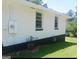 Side exterior of the house features a newly painted white brick exterior with black trim and lush green lawn at 4814 Glenwood Rd, Decatur, GA 30035