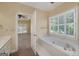 Bathroom showcasing a bathtub with tiled surround and natural light at 170 Glen Eagle Way, Mcdonough, GA 30253