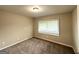 Neutral bedroom features large window, plush carpet, and ample natural light at 1918 Leigh Sw Dr, Conyers, GA 30094