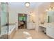 Ensuite bathroom with dual vanities, soaking tub, and access to the bright main bedroom at 235 Ashley Forest Dr, Fayetteville, GA 30214
