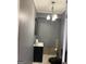 Gray bathroom featuring a single sink, black toilet and fixtures, and a modern light fixture at 413 Atlas Ct, Locust Grove, GA 30248