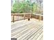 Spacious wooden deck featuring a natural wood stain with railing overlooking wooded backyard at 413 Atlas Ct, Locust Grove, GA 30248