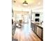 Open kitchen featuring grey cabinets, granite countertops, wood floors, stainless appliances and modern lighting at 413 Atlas Ct, Locust Grove, GA 30248