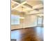 Living room with hardwood floors, coffered ceilings, wainscoting, and abundant natural light at 413 Atlas Ct, Locust Grove, GA 30248