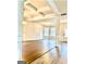 Open living room featuring wood-look floors, decorative ceiling beams, white trim and a doorway to the exterior at 413 Atlas Ct, Locust Grove, GA 30248